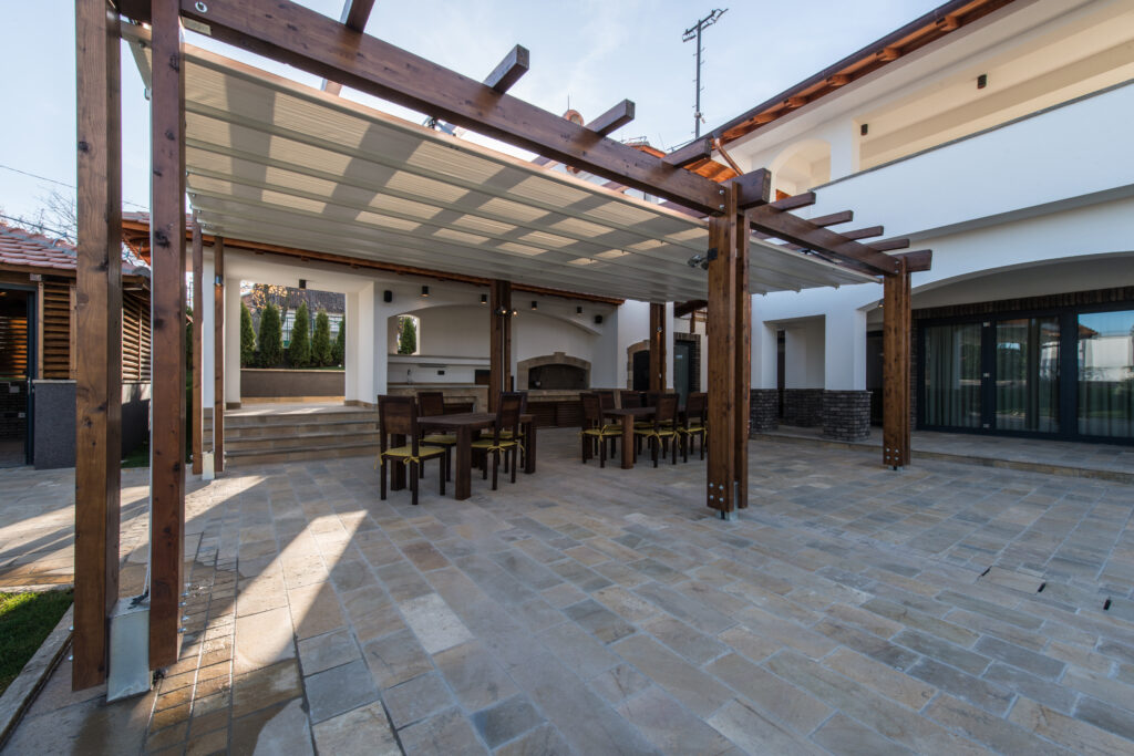 A concrete terrace (made to look like stone) has a pergola that adds significant shade